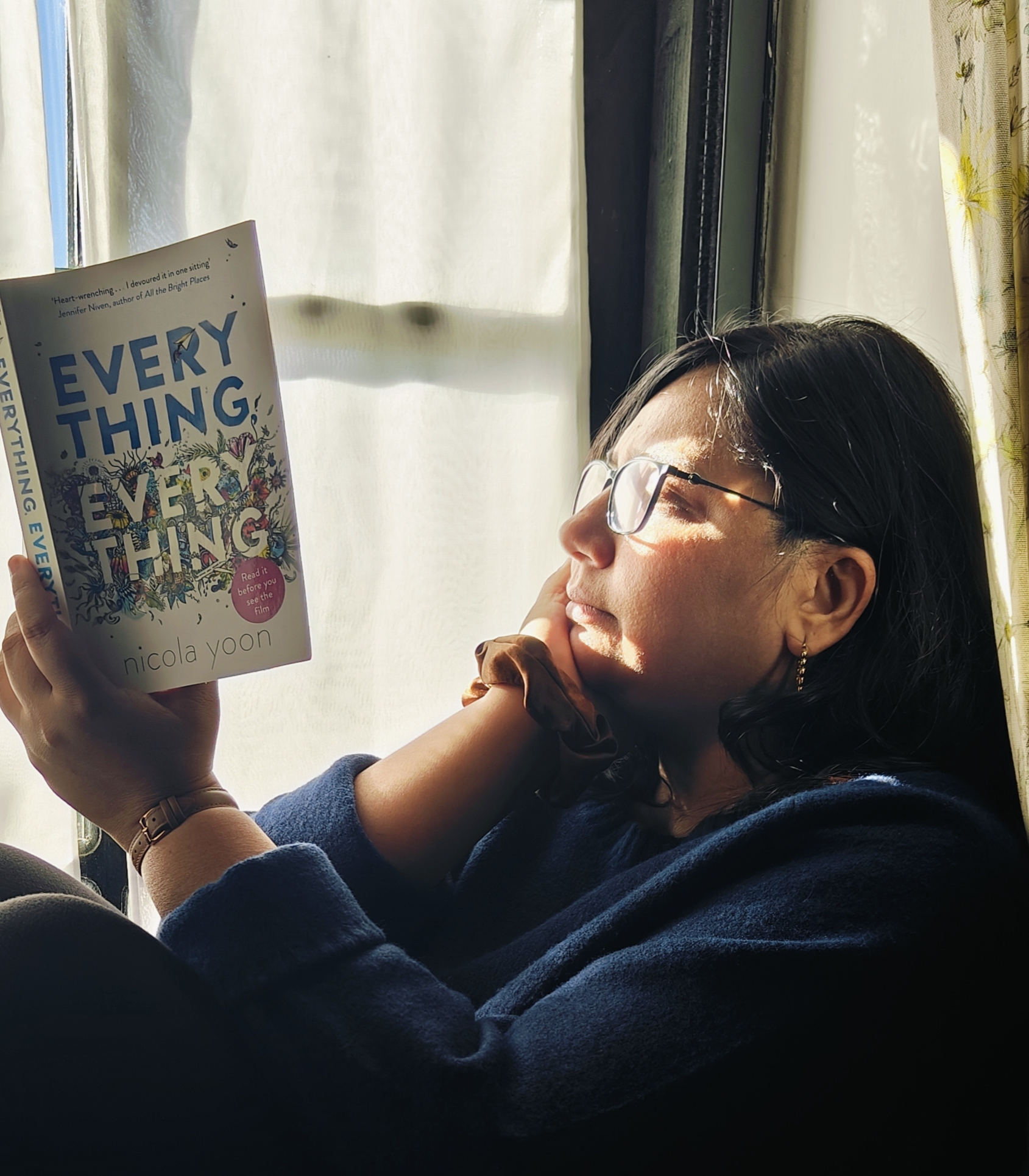 Amruta Ranade reading by the window